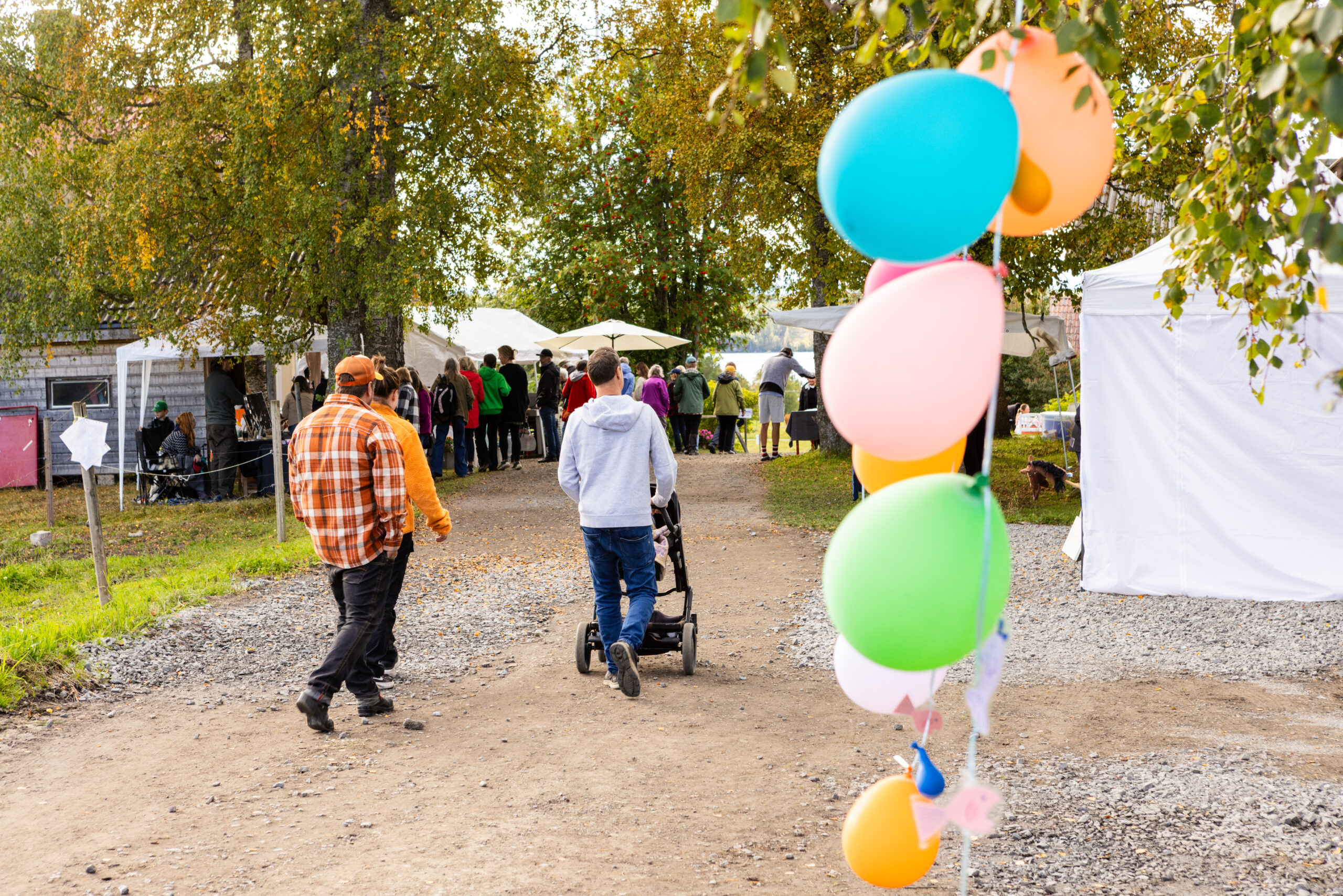 Two people walking around tents at the Harvest Festival.